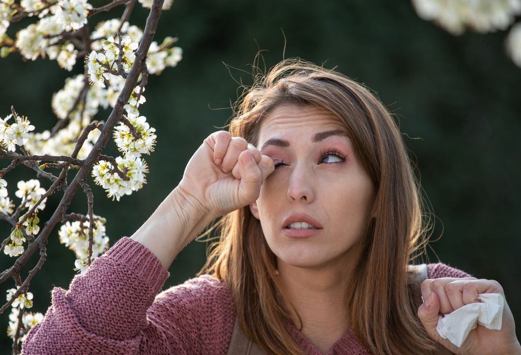 Woman rubbing eyes with allergies 