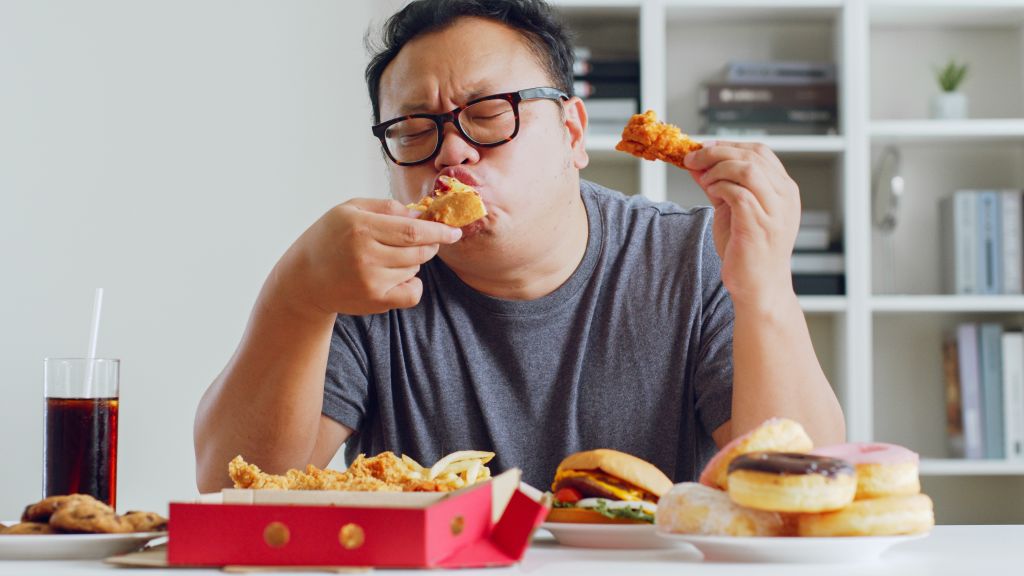 Man eating unhealthy foods 