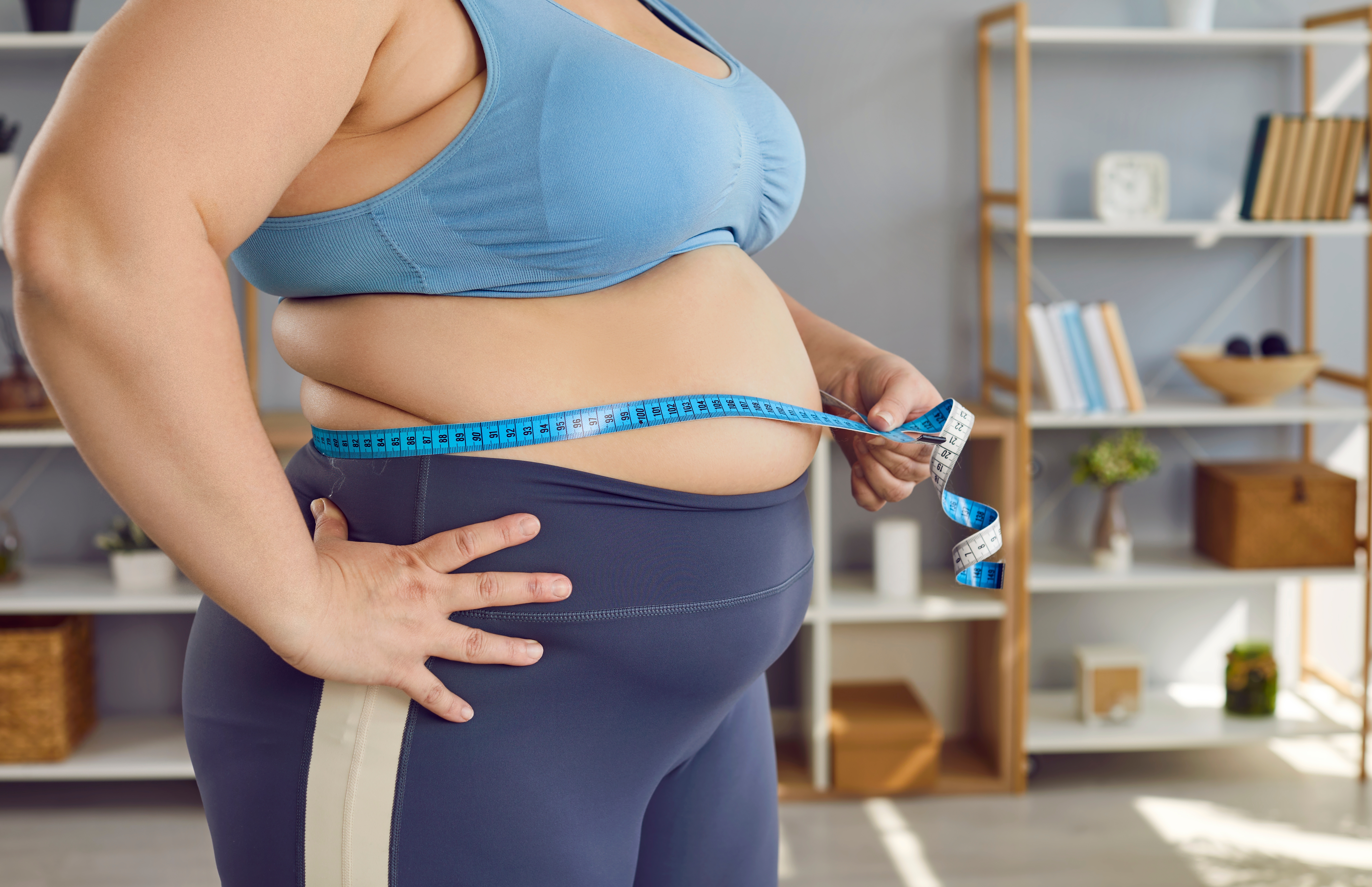 Overweight woman measuring her stomach
