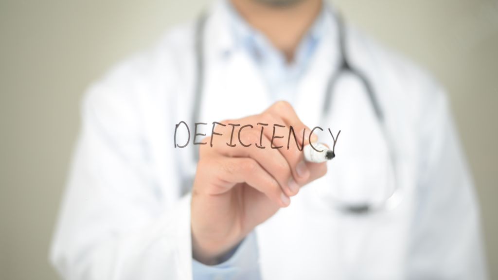 doctor writing the word deficiency 