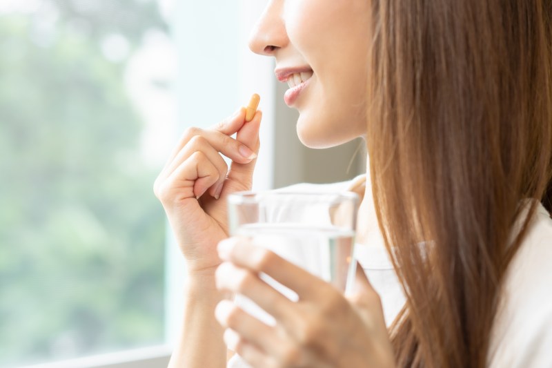 Women taking a pill with water