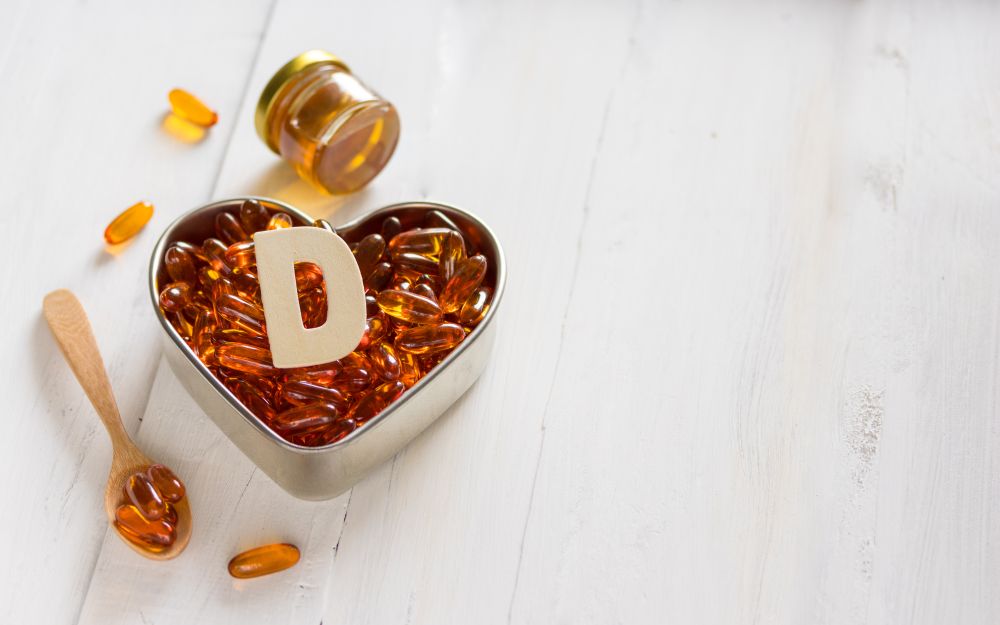 Vitamin D capsules on heart-shaped plate 