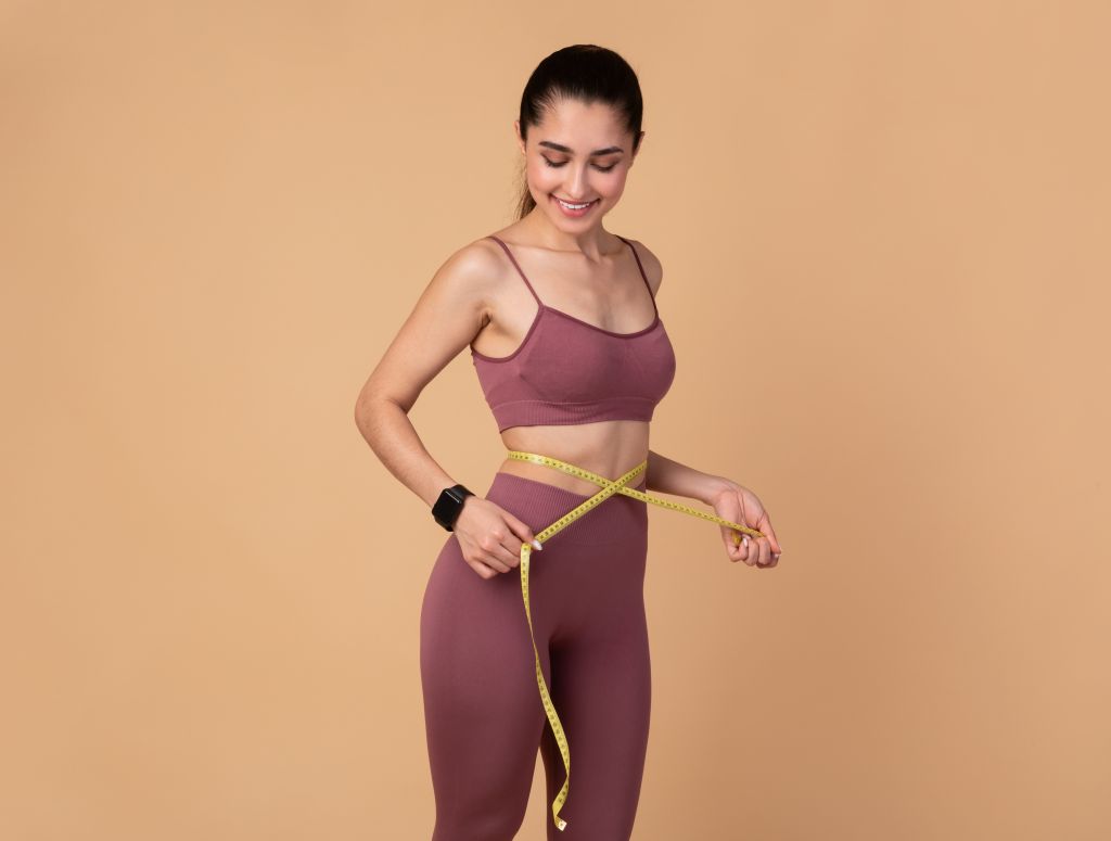 woman measuring her waist