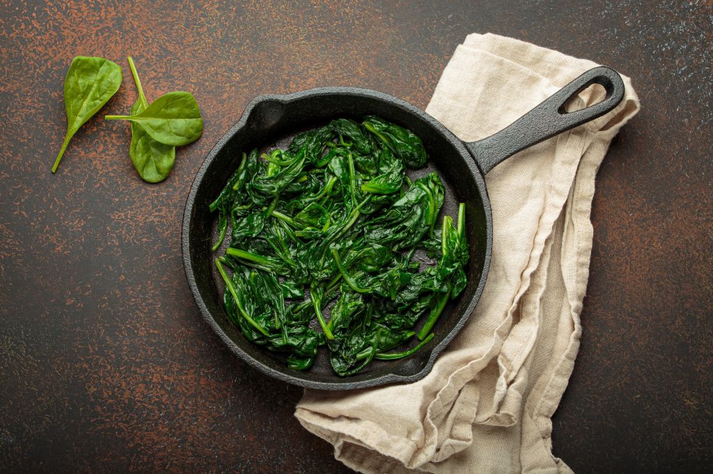 Lightly cooked spinach in a pan and Does Spinach Have Iron?
