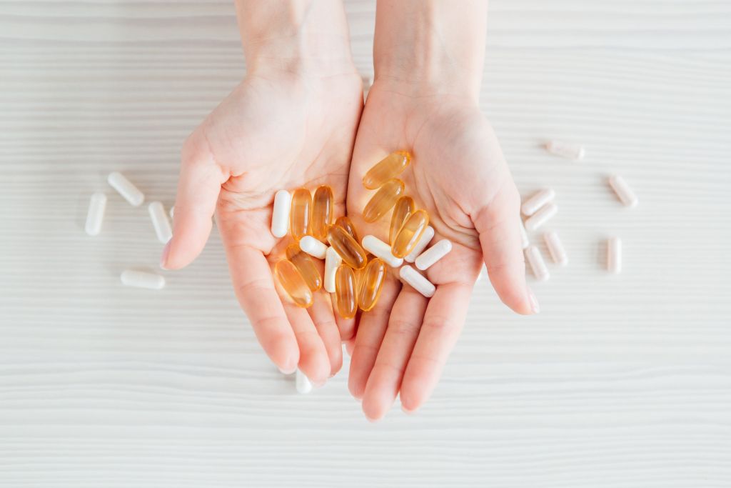 Two hands holding dietary supplements