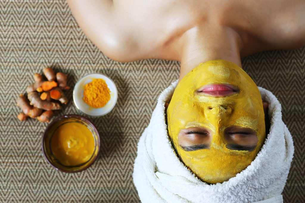 Woman with turmeric facial mask 