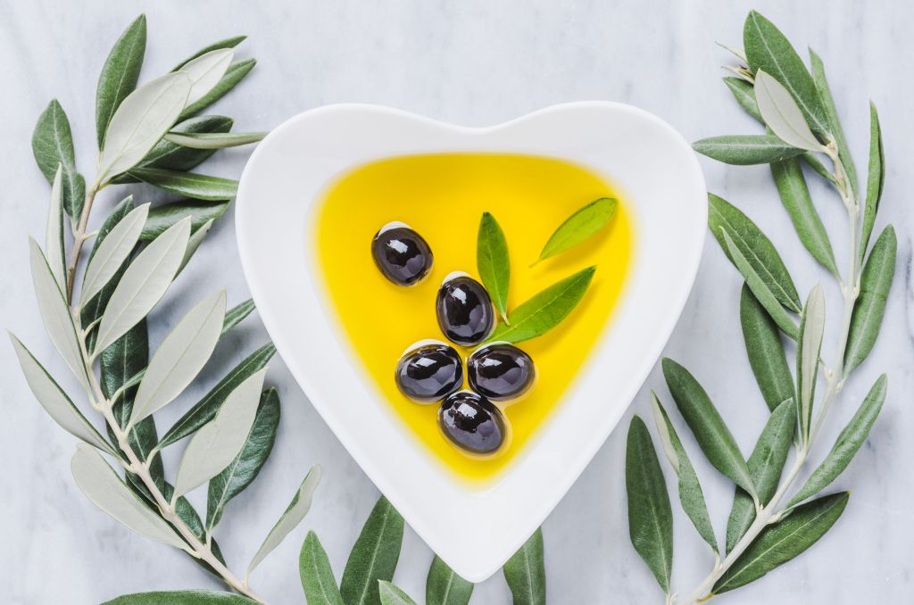 Olive oil and olives in heart plate 