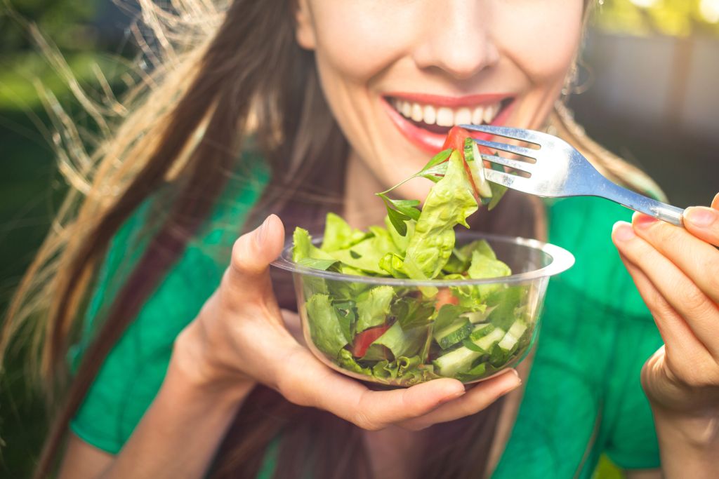 Woman eating a green salad  