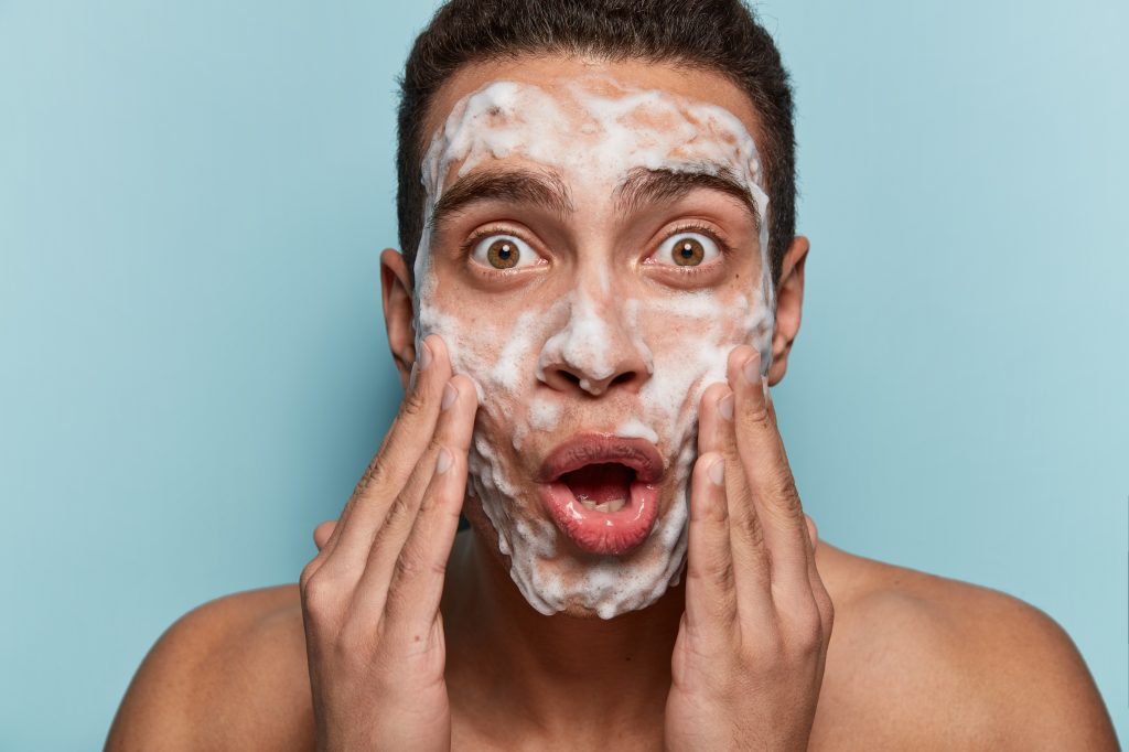 Young man washing his face