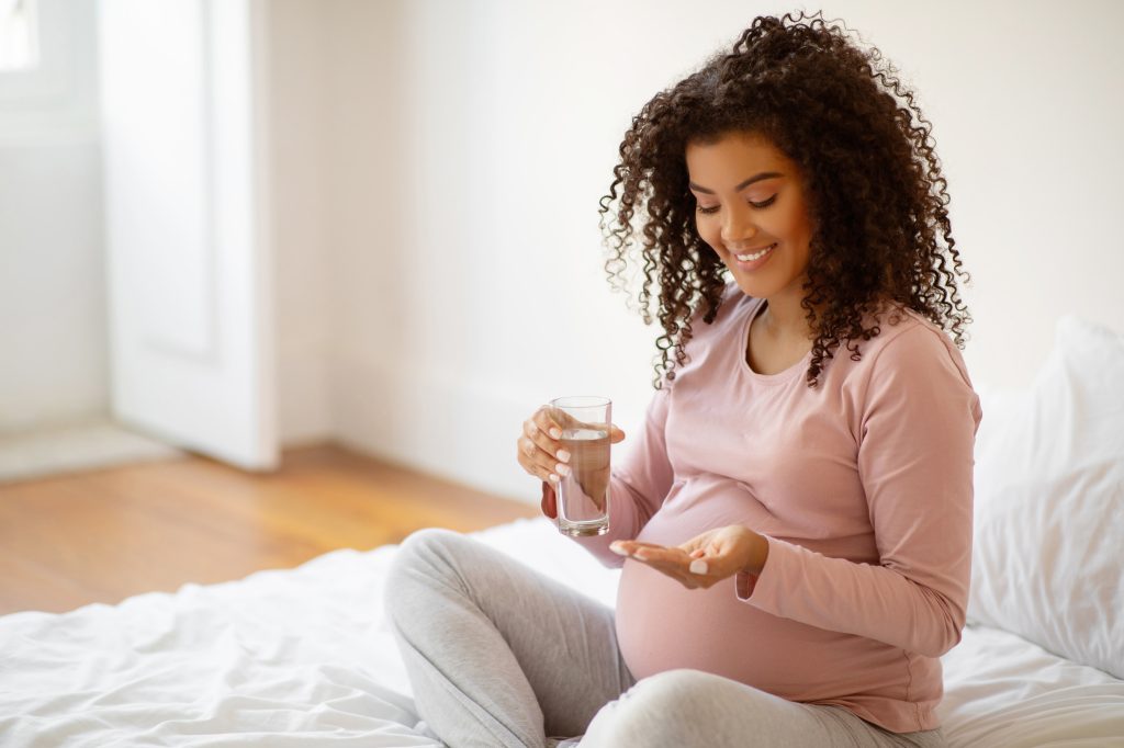 Pregnant woman taking a supplement