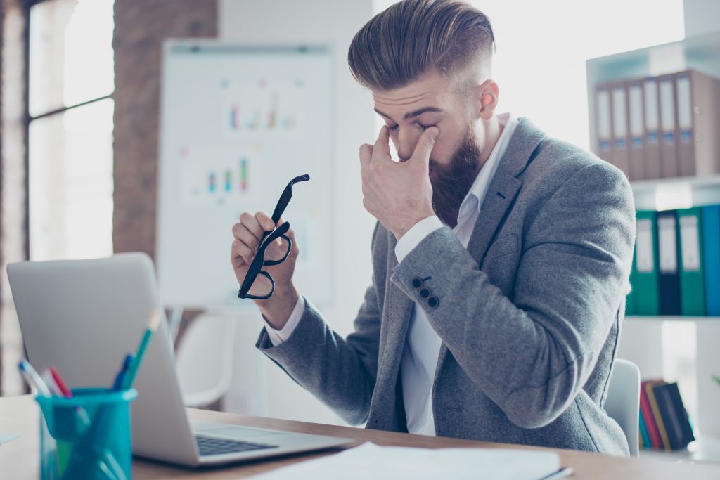 Overworked man rubbing eyes
