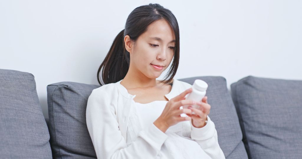 Woman checking supplement label 