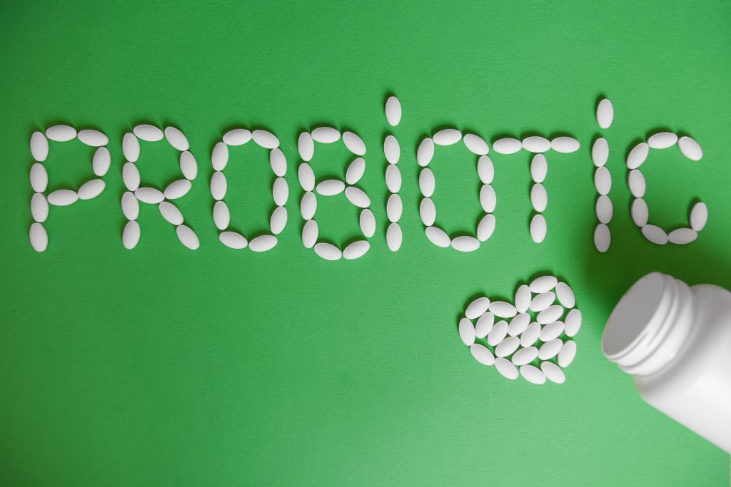 Probiotic pills on green background 