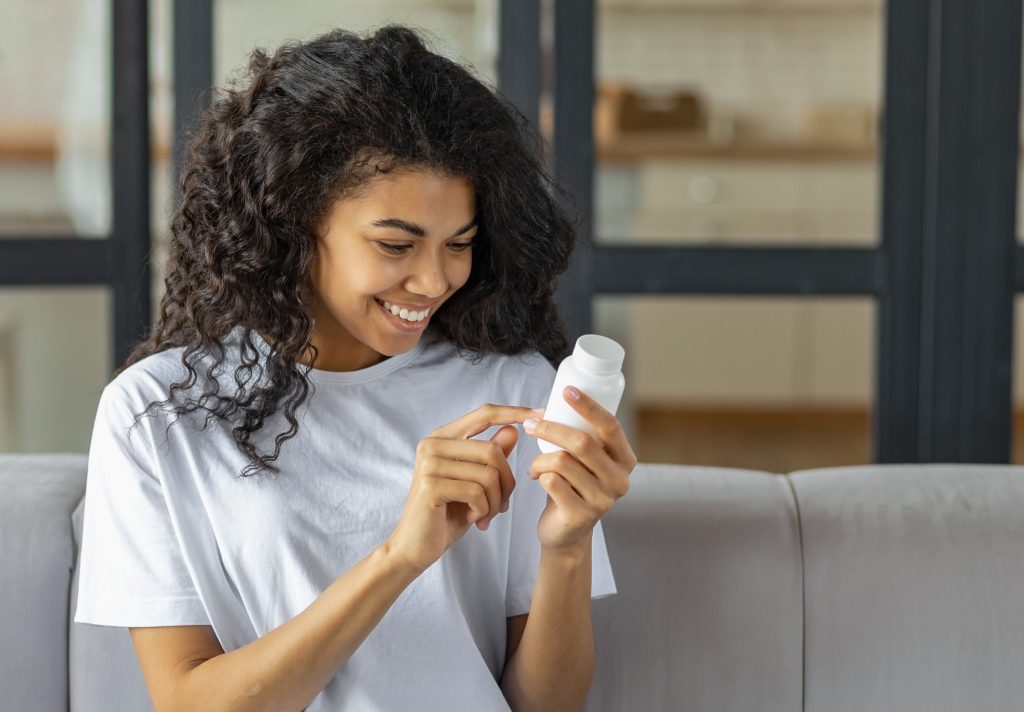Woman holding a supplement container  