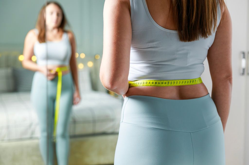 Woman measuring her waist 