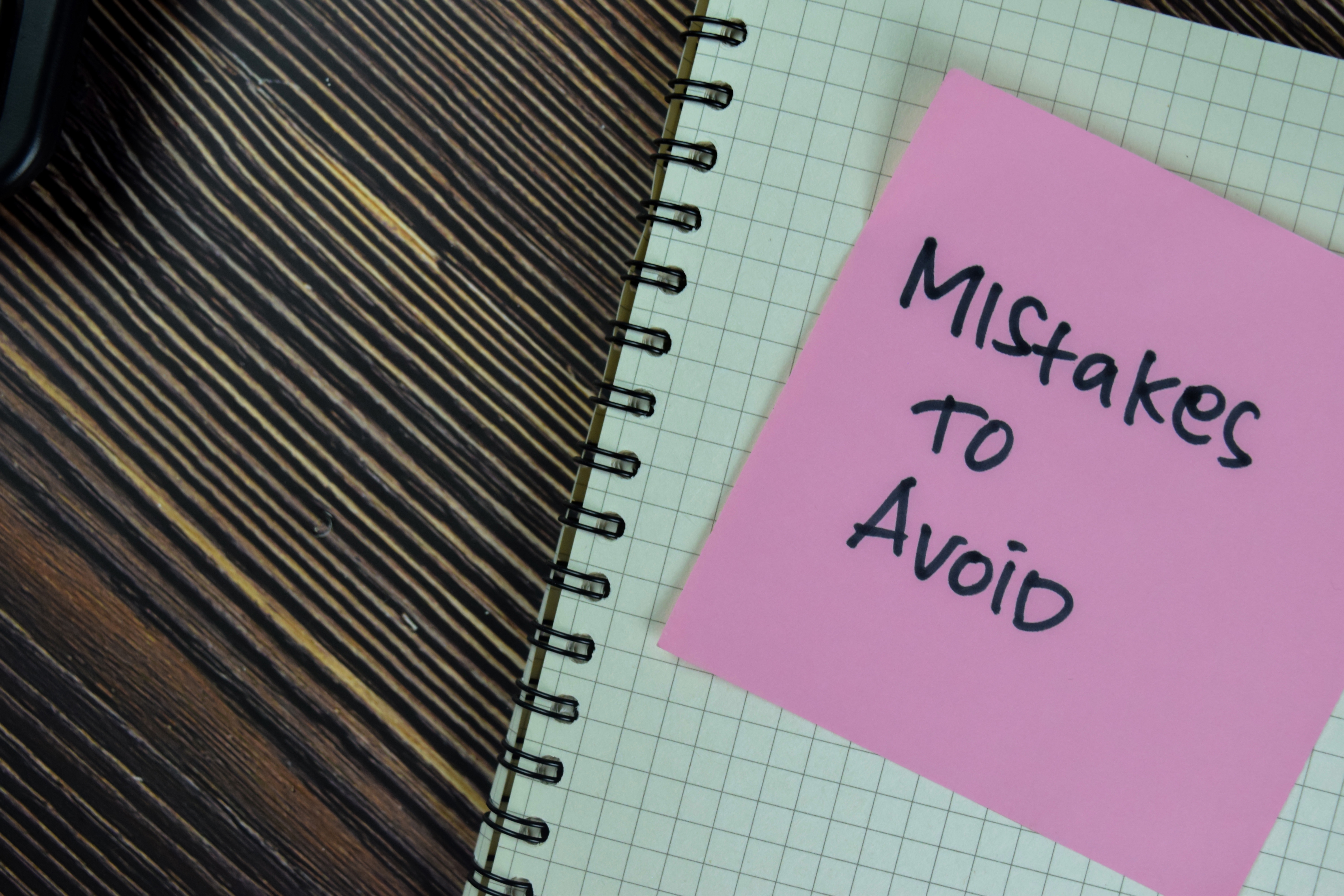 Mistakes to avoid written on a Post-it note  