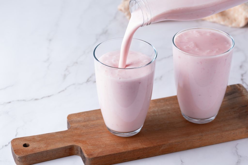 Pouring berry kefir into a glass