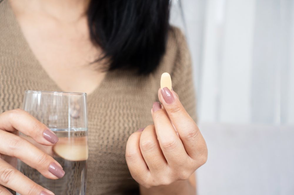 Woman about to take a supplement