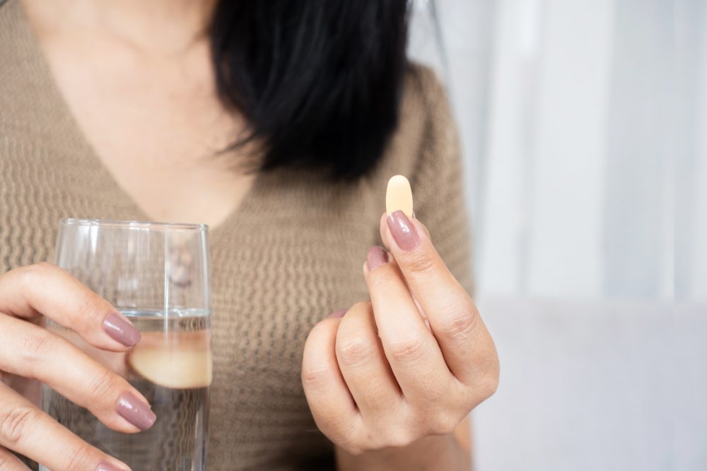 Woman about to take a supplement