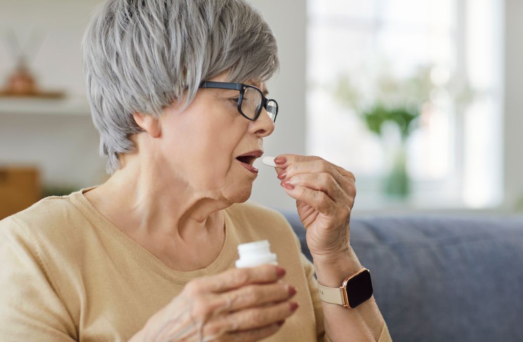 Elderly woman taking a B-complex vitamin 