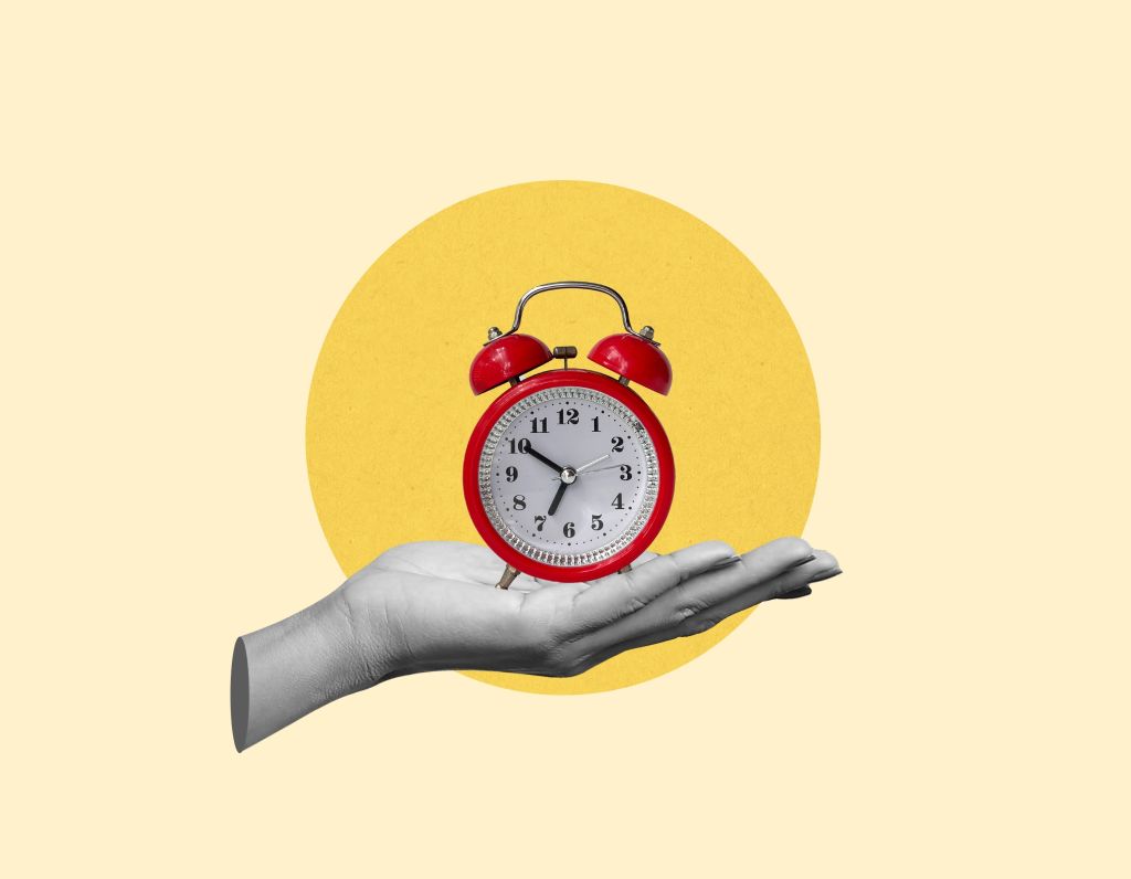 Hand holding an alarm clock