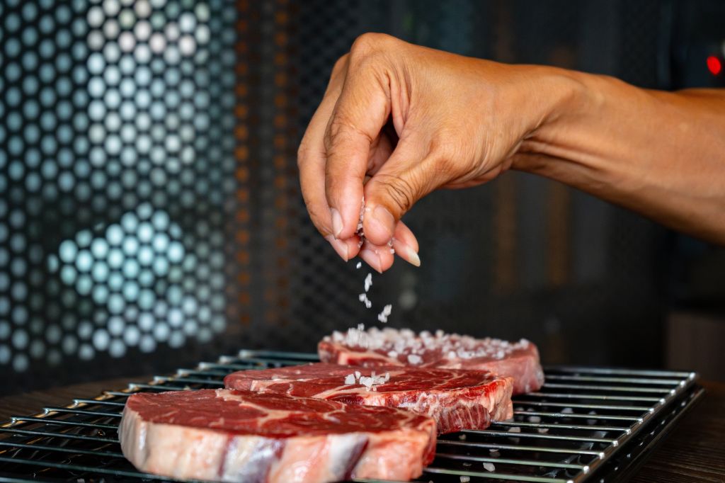 Salting steaks on the grill