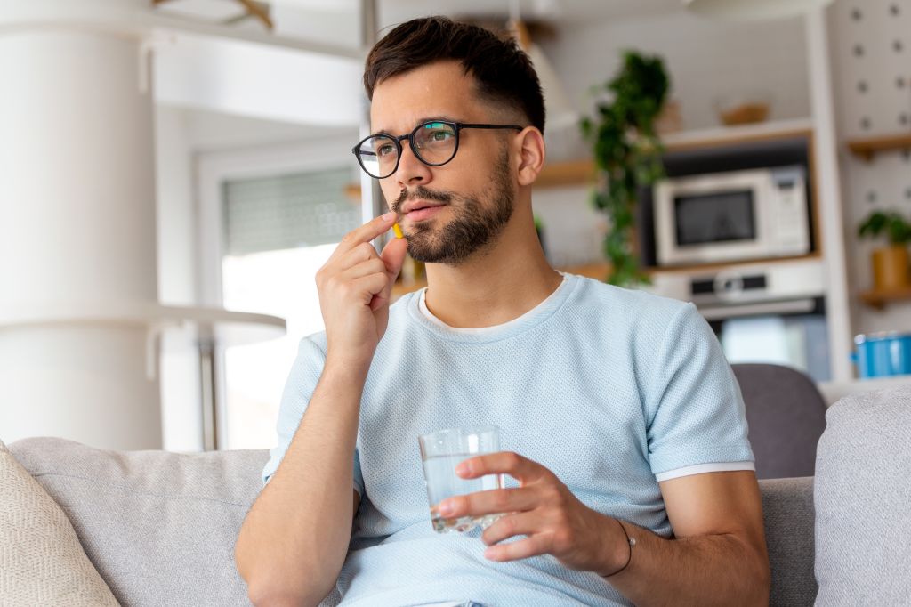 Young man taking a pill