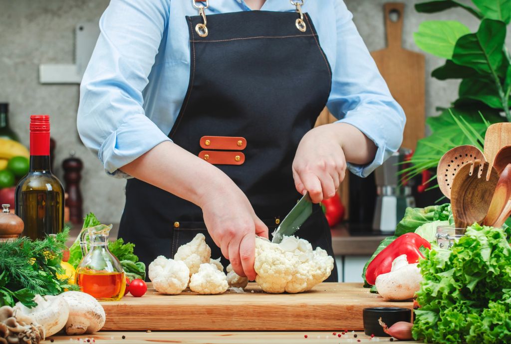 Woman chopping cauliflower 