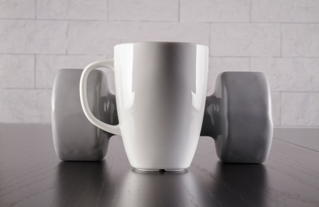 Coffee mug in front of a dumbbell