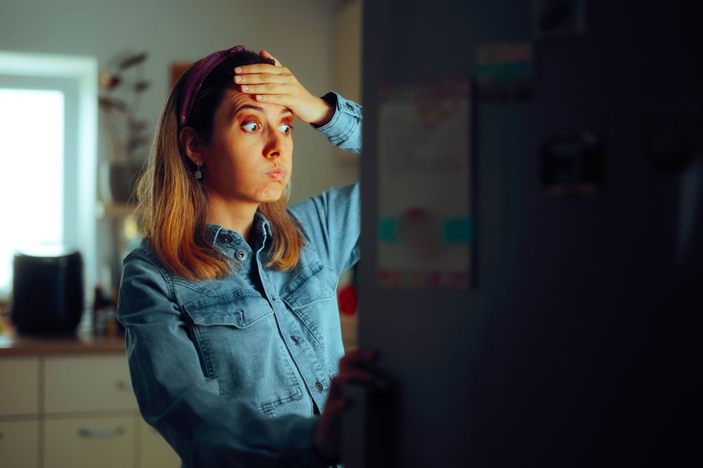 Stressed woman looking in the fridge
