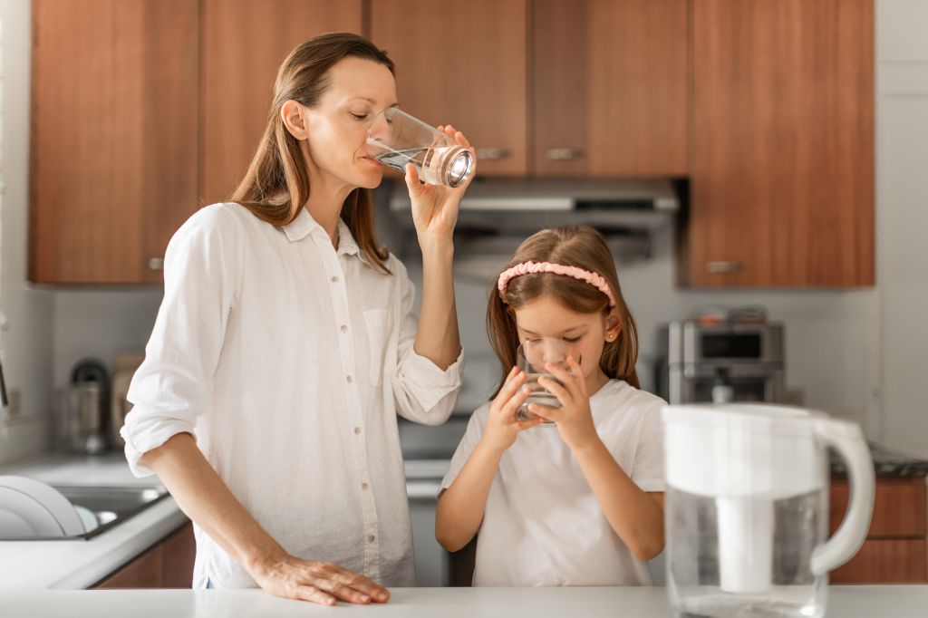 Mother and daughter drinking water